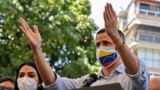 Opposition leader Juan Guaido, wearing a face mask depicting the Venezuelan flag, gestures while speaking during a press conference at Los Palos Grandes square in the Chacao neighborhood, Caracas on May 12, 2021. (Photo by Yuri CORTEZ / AFP)