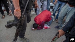 A demonstrator begs a police officer to allow them to proceed ahead during a protest against the Citizenship Amendment Bill (CAB) in Gauhati, India, Dec. 11, 2019. 