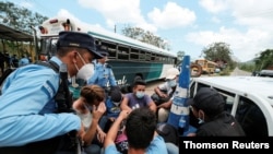 Niños no acompañados y personas con documentación incompleta, en una caravana de migrantes con rumbo a EE. UU., en una camioneta en un puesto de control de la policía hondureña, cerca del paso fronterizo de Corinto con Guatemala. 30 de marzo de 2021. 