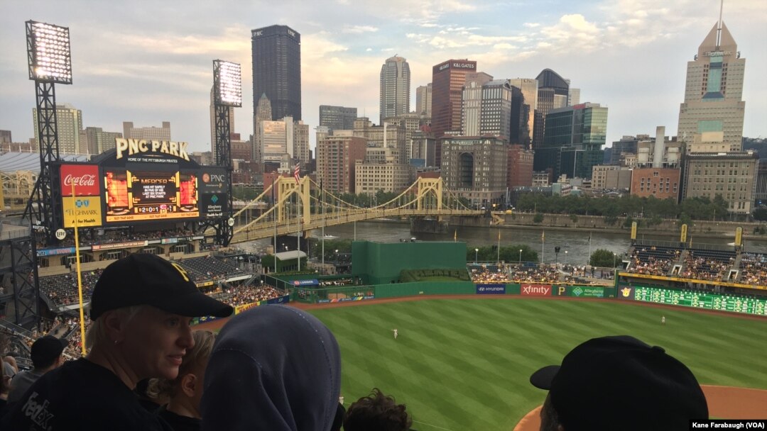 M. Kazam Hashimi dan keluarganya, pengungsi dari Afghanistan, mengikuti acara bagi pengungsi dan imigran Hello Neighbor di PNC Park, 1 Agustus 2017, dengan mentor mereka yang warga Amerika Michelle Boehm dan keluarganya di Pittsburgh.