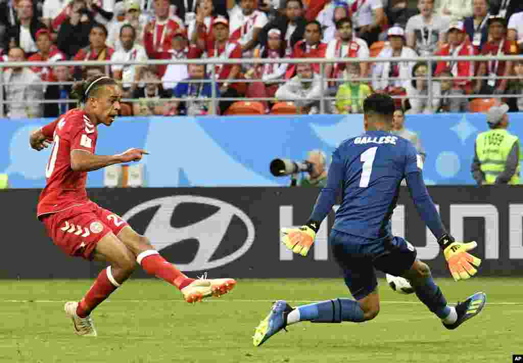 Le Danois Yussuf Yurary Poulsen, à gauche, décoche un tir face au gardien péruvien au cours du match du groupe C entre le Pérou et le Danemark à la Coupe du monde de football 2018 à Mordovia Arena à Saransk, Russie, 16 juin 2018.