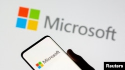 FILE: Smartphone is seen in front of Microsoft logo displayed in this illustration. Taken July 26, 2021. 