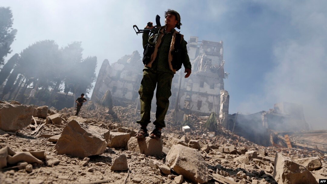 Houthi rebel fighters inspect the damage after a reported airstrike carried out by the Saudi-led coalition targeted the presidential palace in the Yemeni capital Sana'a, Dec. 5, 2017.
