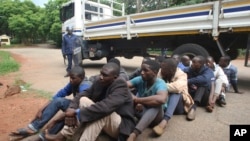 A policeman stands guard as some of the people arrested during demonstrations over the hike in fuel prices, make their court appearance at the magistrates courts in Harare, Zimbabwe, Wednesday, Jan,16, 2019. 