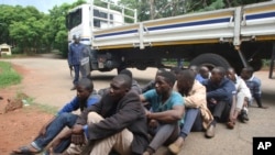 A policeman stands guard as some of the people arrested during demonstrations over the hike in fuel prices, make their court appearance at the magistrates courts in Harare, Zimbabwe, Wednesday, Jan,16, 2019. 