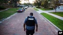 A police officer walks toward a crime scene in Florida. Four police officers were shot in two separate shootings in two Florida cities, Aug. 19, 2017.