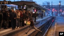 Seorang calon penumpang melintasi rel kereta api pada jam-jam sibuk di stasiun kereta Gare de Lyon, Paris, 3 April, 2018. (Foto: dok). 