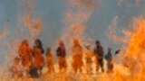 Afghan children watch burning expired medical items and food on the outskirts of Jalalabad. 