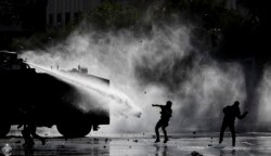 Police spray demonstrators with a water cannon during an anti-government protest in Santiago, Chile, Nov. 5, 2019.