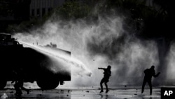 Police spray demonstrators with a water cannon during an anti-government protest in Santiago, Chile, Nov. 5, 2019.