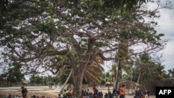 FILE - Residents gather for a meeting in the recently attacked village of Aldeia da Paz outside Macomia, northern Mozambique, Aug. 24, 2019. 