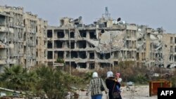 Residents of a suburban neighborhood on the edge of the northern Syrian city of Aleppo return to their homes to check the damage caused by fighting between regime forces and rebel fighters.