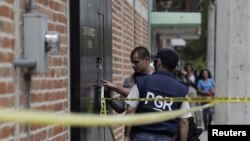 Agen federal memeriksa bekas letusan peluru di Ocotlan, Meksiko. Sebanyak 10 orang tewas dalam baku tembak ketika tersangka anggota geng menyerang konvoi polisi, 20 Maret 2015. (Foto: Reuters)