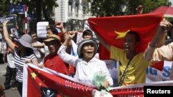 Protesters hold banners while chanting slogans during an anti-China protest along a street in Hanoi, July 22, 2012.