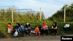 Un grupo de migrantes descansan en el lado serbio de la frontera, cerca de Sid, Croacia, el miércoles 16 de septiembre de 2015.
