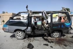 FILE - Afghan journalists film the site of a bomb explosion in Kabul, Afghanistan, June 3, 2021.