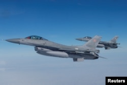 En vuelo dos aviones de combate F-16 de la flota de seguridad aérea de la OTAN.