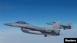 Los aviones F-16 vuelan durante un evento de exhibición de la OTAN en una base aérea en Malbork, Polonia, el 21 de marzo de 2023.