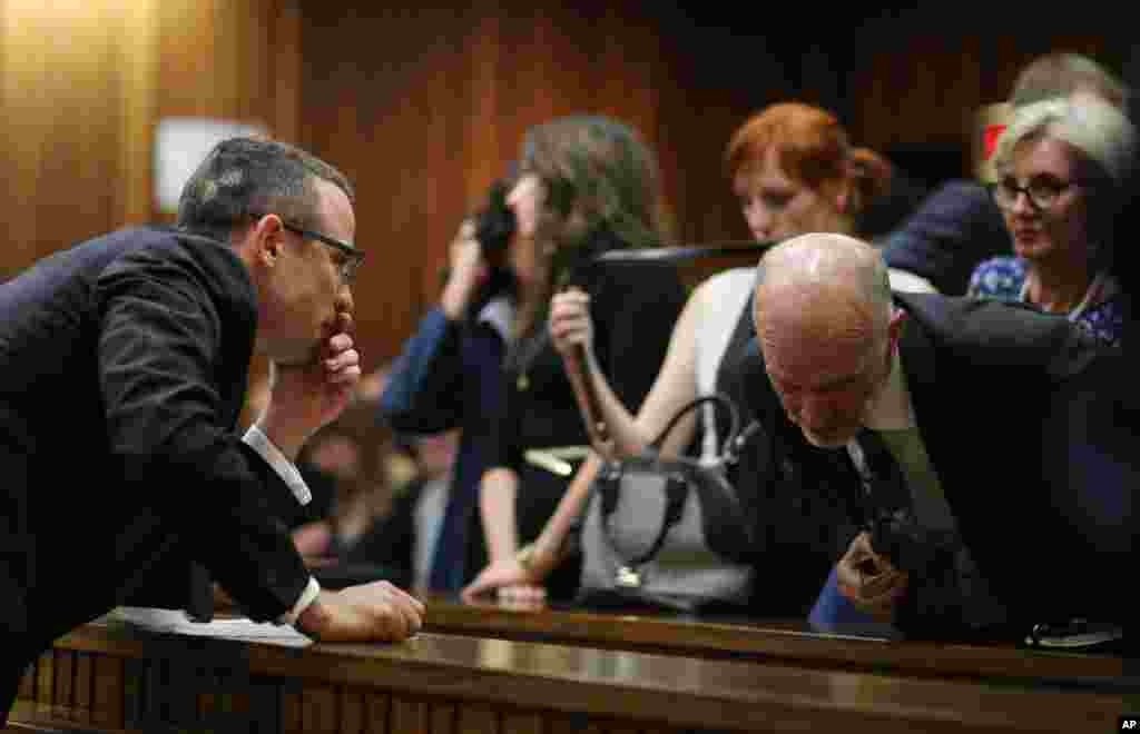 Oscar Pistorius talks with his uncle Arnold Pistorius during his murder trial in Pretoria, South Africa, May 13, 2014.