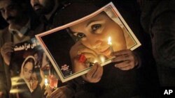 Supporters of Pakistan's slain leader Benazir Bhutto hold candles and her portraits at a ceremony to mark the third anniversary of her death in Islamabad, Pakistan, Dec. 27, 2010.