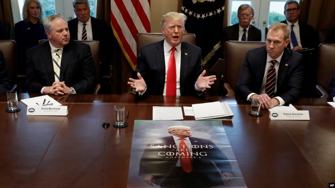 Predsjednik Trump na sastanku kabineta u Bijeloj kući, dok se na stolu ispred nalazi poster s njegovim likom (Foto: AP/Evan Vucci)