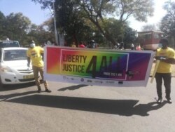 Two LGBTI community members carry a banner calling for equal rights during the parade. (Courtesy of Nyasa Rainbow Alliance)
