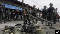 Thai bomb squad members and soldiers inspect the site of a failed bomb attack blamed by police on separatist insurgents in the Sungaipadi distrist of Thailand's restive southern province of Narathiwat, 1 Jan 2011