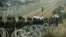 Polish soldiers and police watch migrants at the Poland/Belarus border near Kuznica, Poland, November 11, 2021, in this photograph released by the Territorial Defence Forces. 