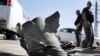 Israeli bomb technicians inspect the remains of a rocket that was fired from the Gaza Strip and landed near the southern city of Ashkelon, February 26, 2013.