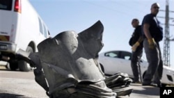 Israeli bomb technicians inspect the remains of a rocket fired from the Gaza Strip which landed near the southern city of Ashkelon on February 26, 2013.