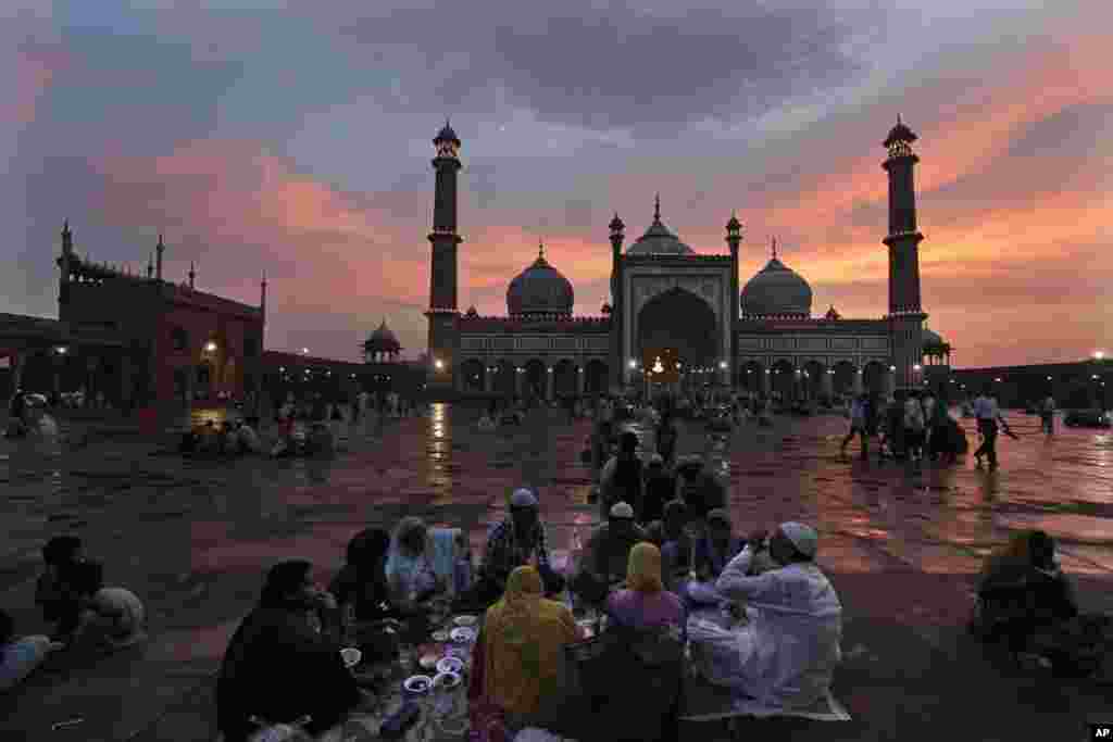 Warga Muslim India berbuka puasa bersama di halaman sebuah masjid di ibukota New Delhi, India.