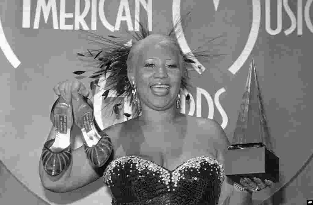 Aretha Franklin holds both shoes and award after being honored during the 10th annual American Music Award presentation in Los Angele, Jan. 17, 1983.