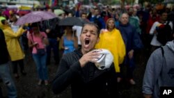 Un manifestante grita durante una protesta gubernamental bajo la lluvia en Caracas, el jueves 13 de abril.