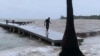 A man walks on a wharf ahead of the arrival of Tropical Storm Sara in West Bay, Roatan, Honduras, on Nov. 14, 2024.