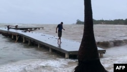 A man walks on a wharf ahead of the arrival of Tropical Storm Sara in West Bay, Roatan, Honduras, on Nov. 14, 2024.