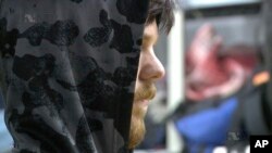 This frame grab from Jan. 28, 2016 taken from a video provided by Mexico's Instituto Nacional de Migracion, INM, shows a hooded Ethan Couch as he is processed by Mexican immigration agents, in Mexico City. 