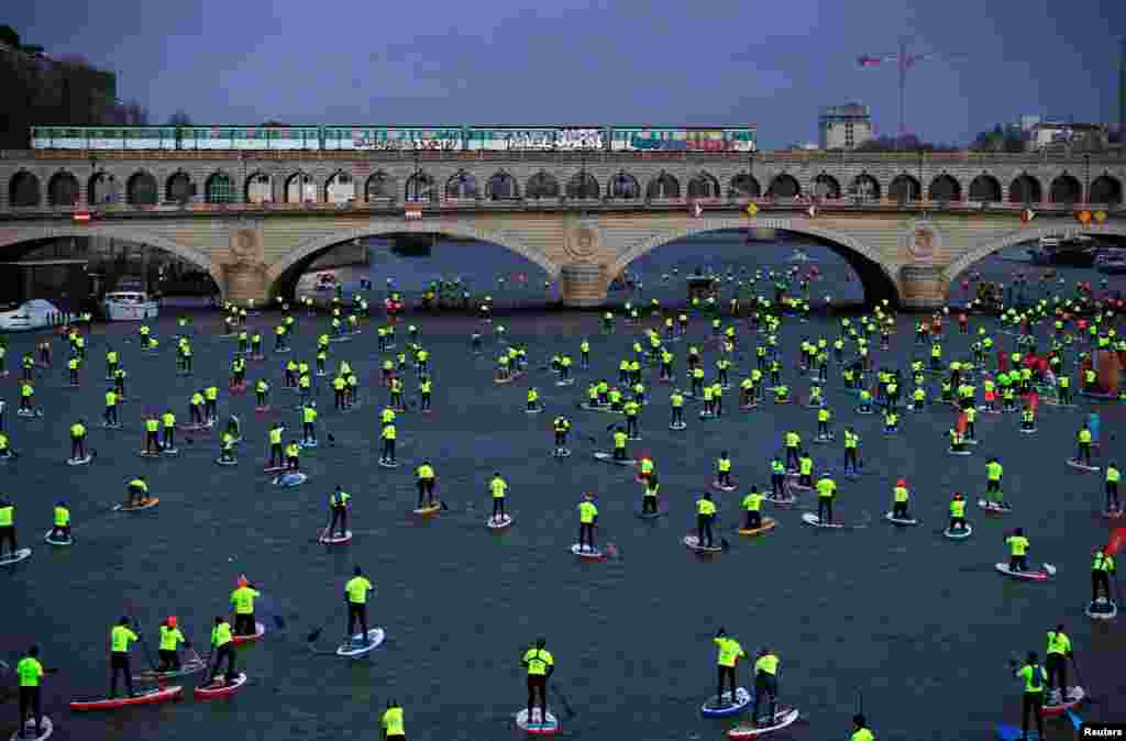 Participants make their way in the 9th Edition of the Nautic SUP Paris Crossing stand up paddle competition on the river Seine in Paris, France.