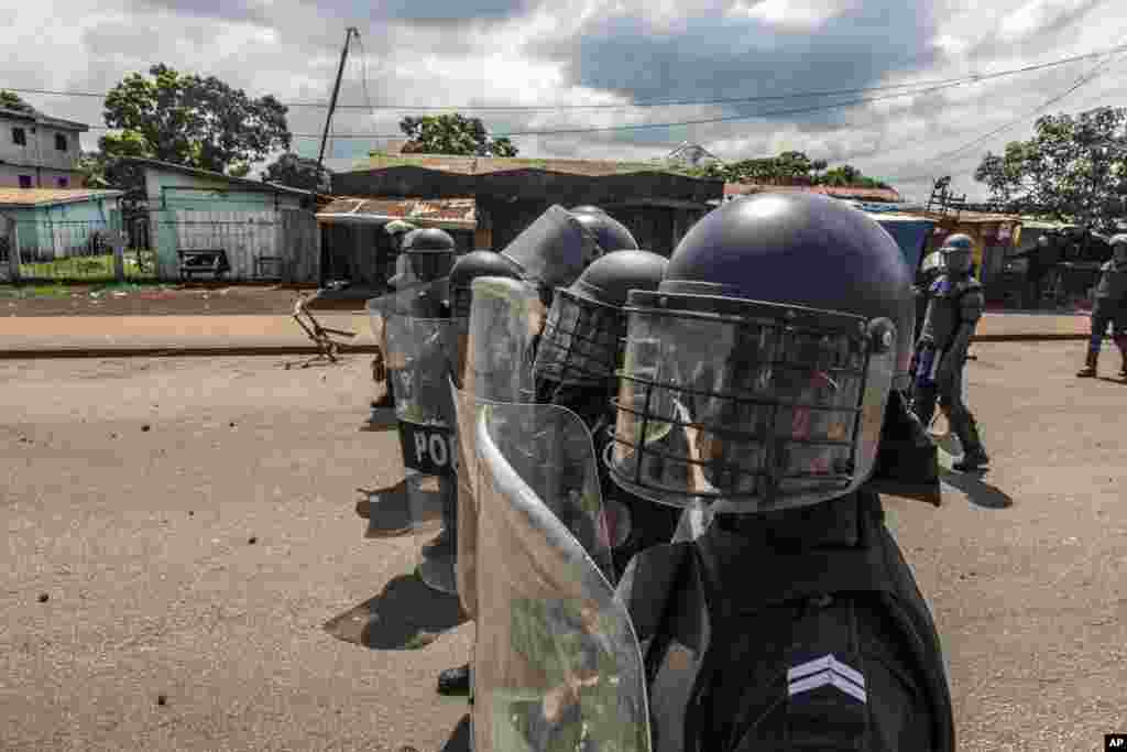 Police face supporters of Guinean opposition leader Cellou Dalein Diallo in Conakry, Guinea, Wednesday, Oct. 21, 2020. Diallo declared himself winner against incumbent President Alpha Conde in Sunday&#39;s presidential elections.(AP Photo/Sadak Souici)
