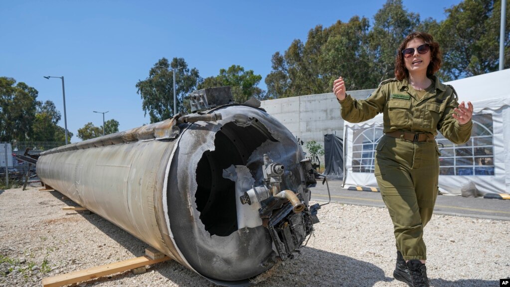  ماشا مایکلسون، معاون بخش مطبوعات بین‌الملل ارتش اسرائیل، یکی از موشک‌های بالستیک جمهوری اسلامی را که اسرائیل در جریان حمله حکومت ایران رهگیری کرد، نشان می‌دهد.