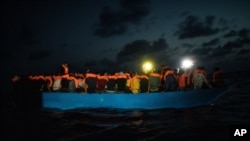 FILE - Dozens of African migrants wait to be assisted by a team of aid workers of the Spanish NGO Open Arms, after spending more than 20 hours at sea, in the Mediterranean Sea, Sept. 8, 2020.