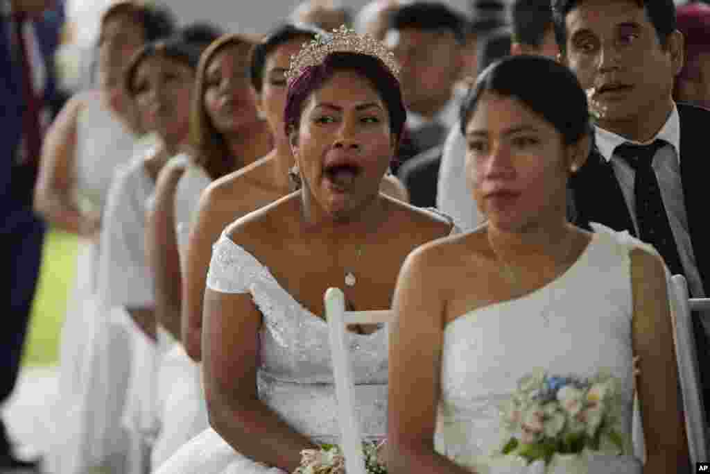 A bride yawns before the start of a free civil wedding organized by the municipality of Lima on the eve of Valentine's Day in Lima, Peru, Feb. 13, 2025.