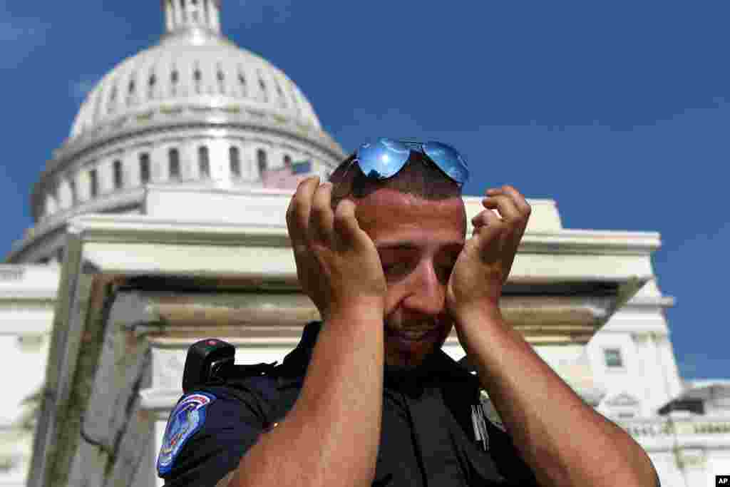 A Capitol Hill police officer wipes sweat from his eyes as he stands his post on the West side of Capitol Hill in Washington, D.C., July 20, 2019. The National Weather Service said &quot;a dangerous heat wave&quot; was expected to break record highs in some places, particularly for nighttime.