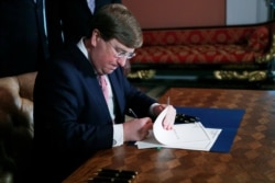 Mississippi Governor Tate Reeves signs the bill retiring the last state flag in the United States with the Confederate battle emblem, during a ceremony at the Governor's Mansion in Jackson, Mississippi, June 30, 2020.