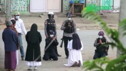 Myanmar nun Sister Ann Rose Nu Tawng kneels in front of police to ask security forces to refrain from violence against children and residents amid anti-coup protests in Myitkyina, Myanmar, March 8, 2021, in this still image taken from video.