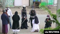 Myanmar nun Sister Ann Rose Nu Tawng kneels in front of police to ask security forces to refrain from violence against children and residents amid anti-coup protests in Myitkyina, Myanmar, March 8, 2021, in this still image taken from video.