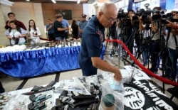 FILE - Philippine National Police Chief Gen. Oscar Albayalde inspects guns, explosives, and Islamic State group-style black flags during a news conference, at Camp Crame in suburban Quezon city northeast of Manila, Philippines, April 1, 2019.