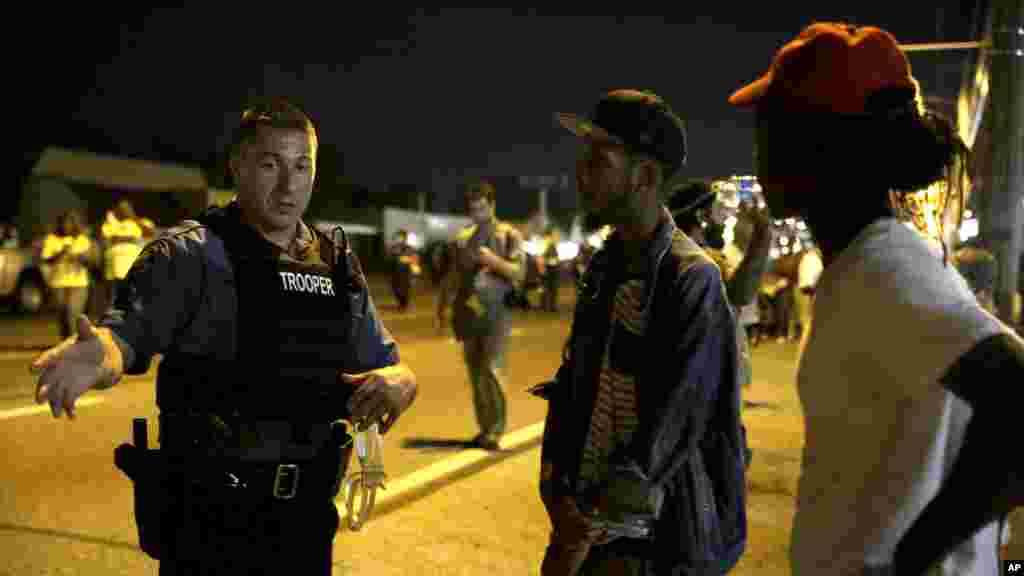 A Missouri State Trooper talks with protesters in Ferguson, Missouri, early Aug. 20, 2014. 