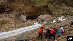 Miembros de los servicios de emergencias durante las tareas de rescate tras el deslave provocado por la crecida del río Naranjo, en las afueras de Ciudad de Guatemala, el 25 de septiembre de 2023. [AP/Moises Castillo]