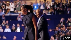 Former US President Barack Obama (L) greets Former US First Lady Michelle Obama on the second day of the Democratic National Convention (DNC) at the United Center in Chicago, Illinois, on August 20, 2024.