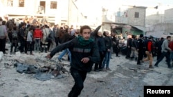 People run after what activists said was the return of government jet planes in Aleppo's al-Marja district December 23, 2013. More than 300 people have been killed in a week of air raids on the northern Syrian city of Aleppo and nearby towns by President 